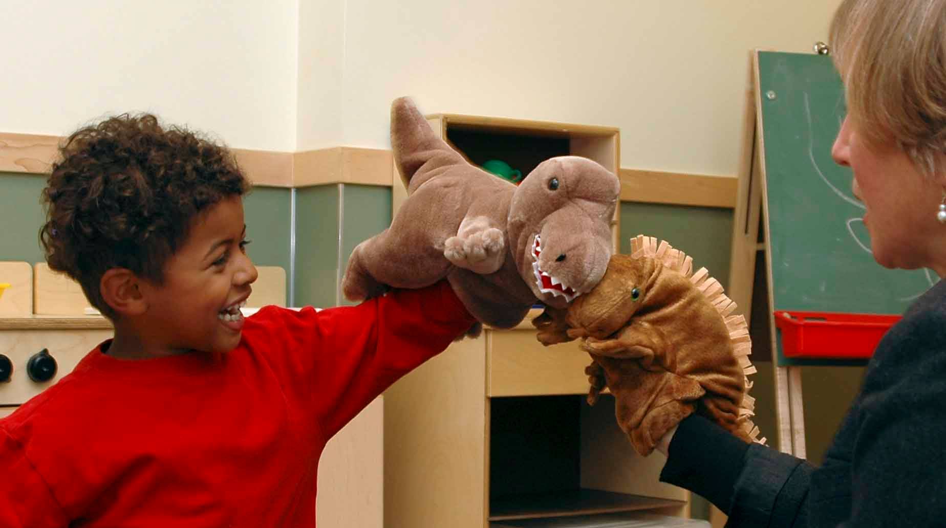 A child and teacher playing with stuffed animals